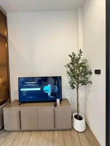 a tv sitting on a cabinet with a potted plant at Edge centarl pattaya luxury sea view in Ban Khok Kham