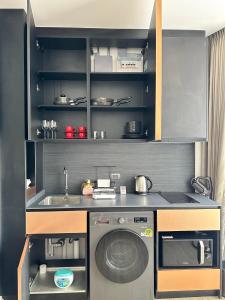 a kitchen with a washing machine and a sink at Edge centarl pattaya luxury sea view in Ban Khok Kham