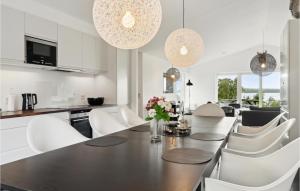 a kitchen and dining room with a table and chairs at Holiday Home Ringmosevej Holbæk V in Kisserup