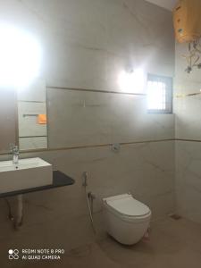 a bathroom with a white toilet and a sink at Malpe Heights - Home Stay in Malpe