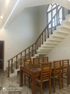 a dining room with a table and some stairs at Malpe Heights - Home Stay in Malpe