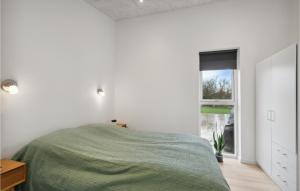 a white bedroom with a bed and a window at Amazing Home In Spøttrup With Wifi in Spottrup +12 photos
