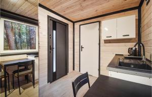 a kitchen and dining room of a tiny house at Beautiful Home In Pogorzelica in Pogorzelica