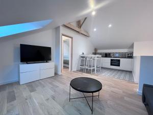 a living room with a flat screen tv and a table at Appartement Lancieux in Lancieux