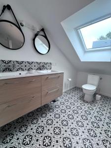 a bathroom with a sink and a toilet and a mirror at Appartement Lancieux in Lancieux