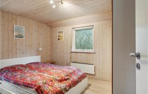 a bedroom with a bed in a room with wooden walls at Lovely Home In Vejby With Kitchen in Vejby