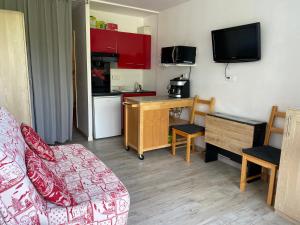 a living room with a couch and a kitchen at Studio aux pieds des pistes in Villard-de-Lans