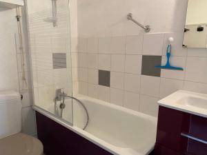 a bathroom with a tub and a toilet and a sink at Studio aux pieds des pistes in Villard-de-Lans