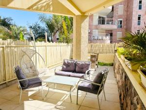 eine Terrasse mit Sofa, Stühlen und einem Tisch in der Unterkunft דירת נופש אילת -אלמוג Almog Suite in Eilat close to Red Sea - דירת נופש אלמוג מרחק נגיעה מהים in Eilat