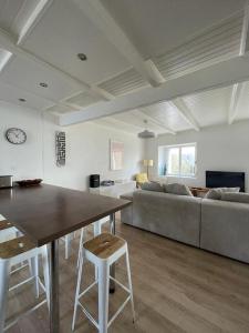 a living room with a table and a couch at Maison de pêcheurs a 100m de l'océan! in Étel