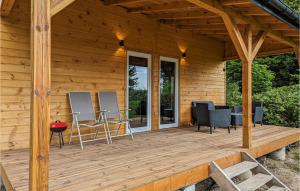 una terrazza in legno con sedie e un tavolo sopra di Nice Home In Karszewo With Wi-Fi a Karszewo