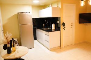 eine kleine Küche mit Kühlschrank und Tisch in der Unterkunft דירת נופש אילת -אלמוג Almog Suite in Eilat close to Red Sea - דירת נופש אלמוג מרחק נגיעה מהים in Eilat