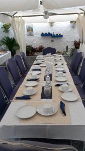 uma mesa longa com pratos e pratos em B&B Gi & Giò em Càbras