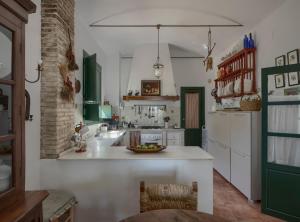 a kitchen with white counters and green cabinets at Finca Olivo Llorón in Montilla