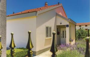 ein kleines Haus mit einem Zaun davor in der Unterkunft Two-Bedroom Holiday Home In Kastel Novi in Kaštela