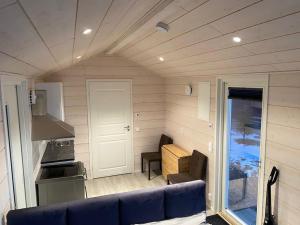 a living room with a blue couch in a tiny house at Northern Lights Haven in Ytre Tomasjord