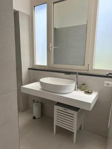 un bagno bianco con lavandino e specchio di Chez Moira apartment with seaview a Ravello