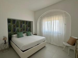 una camera da letto bianca con un letto grande e una finestra di Chez Moira apartment with seaview a Ravello