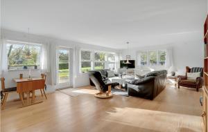 a living room with leather furniture and a table at Holiday Home Stege 35 in Pollerup Kullegård