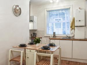 a kitchen with a table and two chairs and a counter at Jet Workers Cottage in Whitby