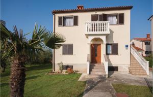 une maison avec un palmier devant dans l'établissement Three-Bedroom Apartment In Peroj, à Peroj