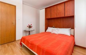 - une chambre avec un grand lit et une couverture orange dans l'établissement Three-Bedroom Apartment In Peroj, à Peroj