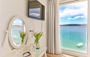 トロギールにあるAmazing Home In Trogir With Saunaのバスルーム(鏡付)、海を見渡す窓が備わります。