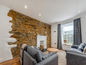 a living room with two couches and a stone wall at Beachey View - Uk43058 in Saundersfoot