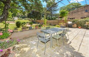 a table and chairs in a garden with plants at Awesome Home In Saint-Rémy-De-Provence in Saint-Rémy-de-Provence
