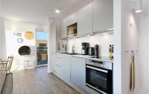 Una cocina con gabinetes blancos y una estufa. en Penthouse Comfort, en Lembruch
