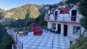 a balcony of a house with a table and chairs at FORTUNE HEIGHTS DALHOUSiE in Dalhousie