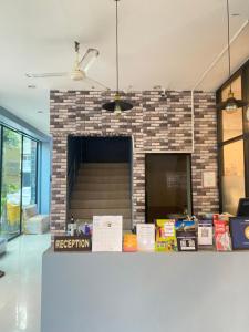 a lobby with a brick fireplace with books on a counter at Holiday Home Patong in Patong Beach