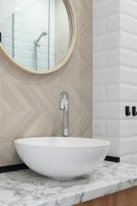 a bathroom with a white sink and a mirror at Hotel TEJ Tower A Family Hotel Near Delhi Airport in New Delhi