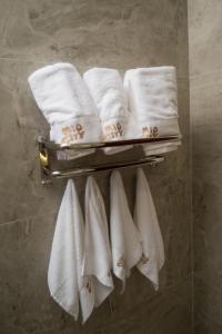 un mucchio di asciugamani appesi a un appendiabiti in bagno di Hotel Mio City a Kula