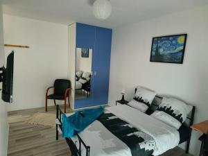 a bedroom with a large bed and a mirror at Chambre privée proche stade de France et Paris dans appartement partagé in Pierrefitte-sur-Seine