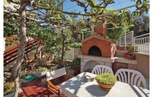 un patio avec une table et un four en briques dans l'établissement Three-Bedroom Apartment In Racisce, à Račišće