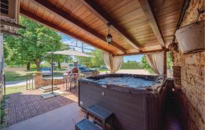 a large hot tub on a patio with a table at 1 Bedroom Amazing Home In Bacva in Bačva