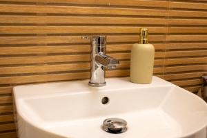 ein Waschbecken mit einer Seifenflasche darüber in der Unterkunft MODERN 2 ROOM Apartment in Rüttenscheid in Essen