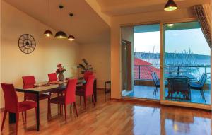 a dining room with a table and chairs and a large window at Three-Bedroom Apartment In Kastel Gomilica in Kaštela