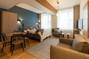 a bedroom and living room with a bed and a table at Postmaster Hotel in Rovaniemi