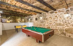 a pool table in a room with a stone wall at Holiday Home Zmijavci I in Zmijavci