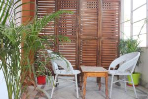 a patio with two chairs and a table and some plants at The Nandi International Boutique Stay in Varanasi
