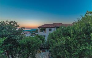 a house with trees in front of a sunset at 1 Bedroom Awesome Apartment In Kolan in Kolan