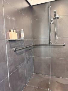 un bagno con doccia con porta in vetro di Tiki Palms Beach House - Corindi Beach a Corindi