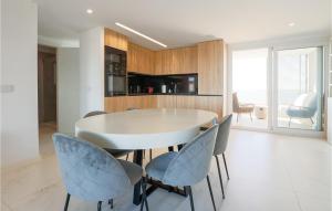 ein Esszimmer mit einem weißen Tisch und blauen Stühlen in der Unterkunft Amazing Apartment - Torrevieja in Torrevieja