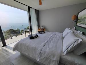 Haad TianVilla Vista, piscine privée à débordement vue mer !的卧室配有白色的床和大窗户 更多9张照片