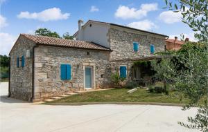 kamienny dom z niebieskimi okiennicami i podjazdem w obiekcie 3 Bedroom Amazing Home In Ruzici w mieście Ružići
