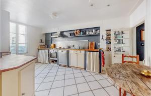 a large kitchen with a wooden table and a wooden table at Lovely Home In Villeneuve-Sur-Yonne in Villeneuve-sur-Yonne