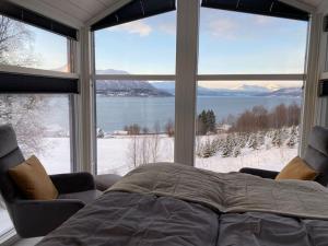1 dormitorio con 1 cama frente a una ventana grande en Arctic Sky Sanctuary, en Ytre Tomasjord