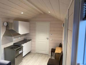 cocina pequeña con fogones y puerta en Arctic Sky Sanctuary, en Ytre Tomasjord